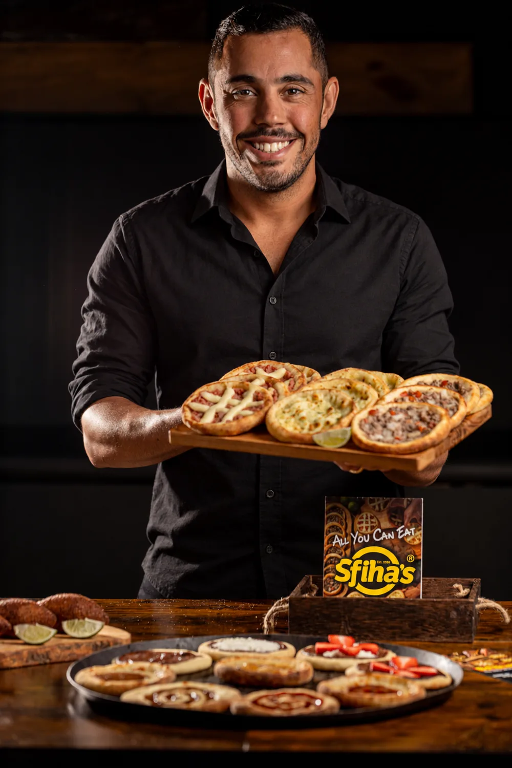 Renan Faria Martins holding a tray of sfihas